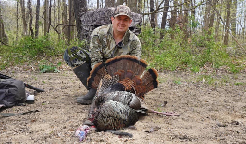Hunter with gobbler in spring woods